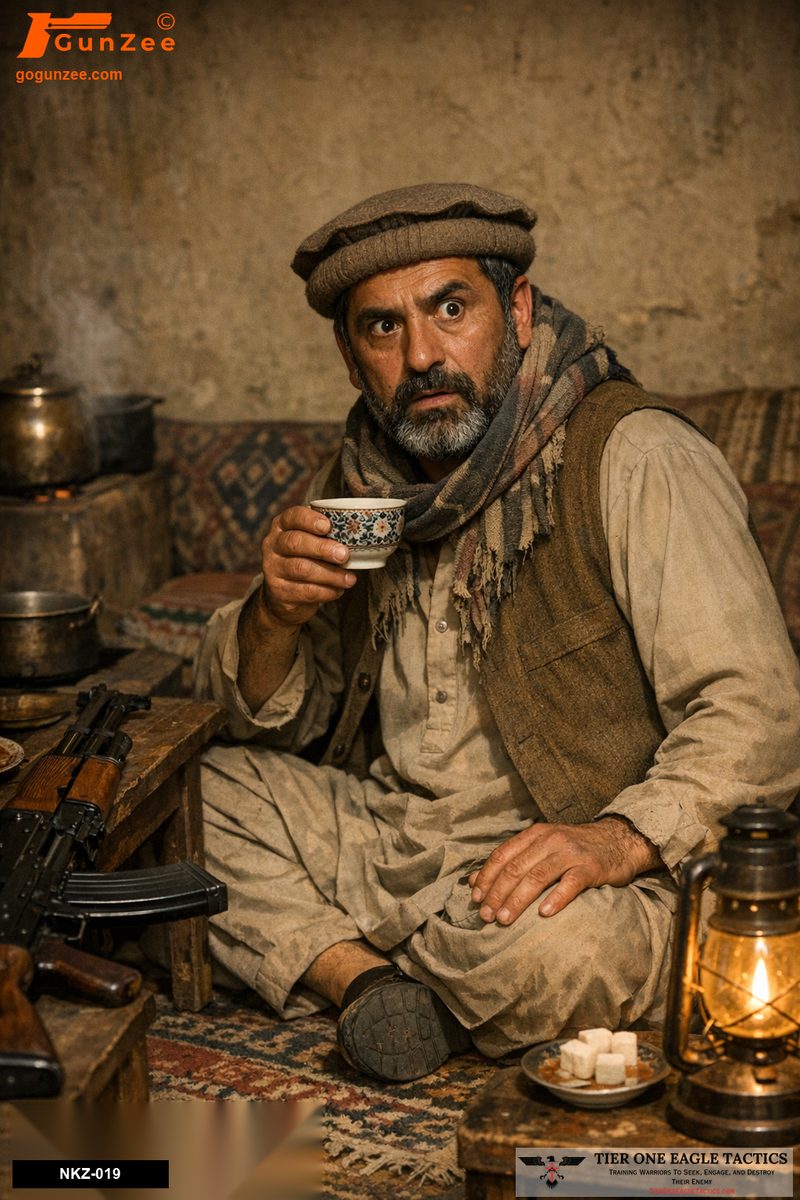 Middle-aged male in Afghan attire holding a teacup, AK-pattern rifle on table, in dimly lit room.