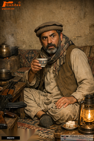 Middle-aged male in Afghan attire holding a teacup, AK-pattern rifle on table, in dimly lit room.